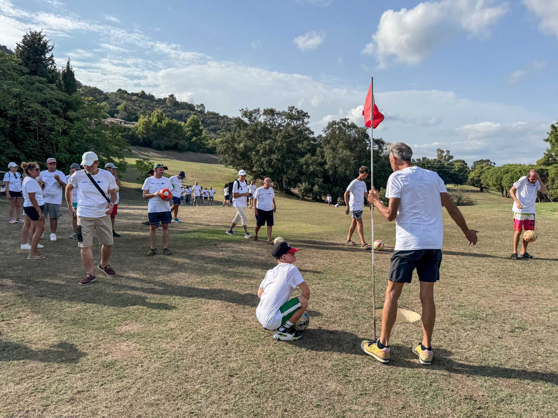 Il gruppo segue una prova di footgolf intorno alla buca con bandierina rossa sul campo dell’Acquabona, Marelba 2026
